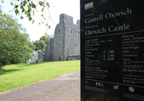 een bord voor een oud kasteel bij Bayview Bungalow 365 in Oxwich