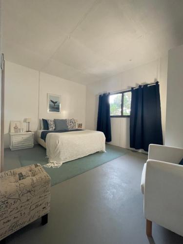 a bedroom with a bed and a window with blue curtains at Casa do Moinho de Baixo in Sesimbra