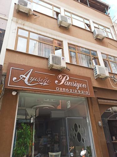 een restaurant met een bord aan de zijkant van een gebouw bij moonlight (AY IŞIĞI ) in Canakkale