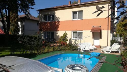 a swimming pool in front of a house at Holiday house Riviera - Balaton - Siófok in Siófok