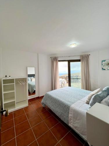 a bedroom with a bed and a large window at La casa de Tenesedra in Mocanal