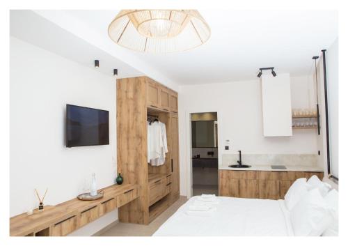 a bedroom with a bed and a tv and a bathroom at Le Quartier Comfy Studios in Parga