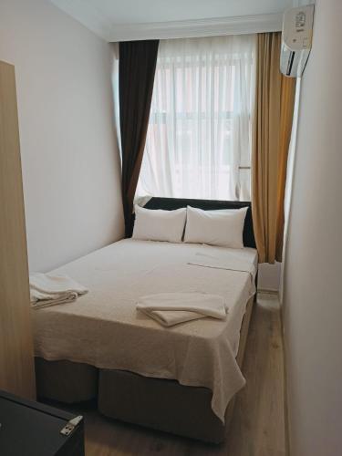 een klein bed in een kamer met een raam bij moonlight (AY IŞIĞI ) in Canakkale
