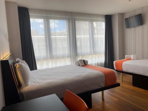 um quarto de hotel com duas camas e uma janela em easyHotel Lisbon em Lisboa