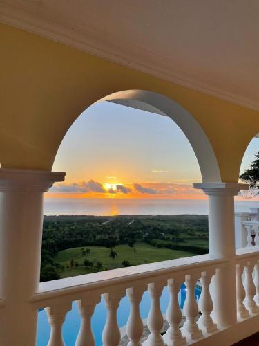 a view of the ocean from a balcony with a sunset at El Castillo Tropical in Cabrera