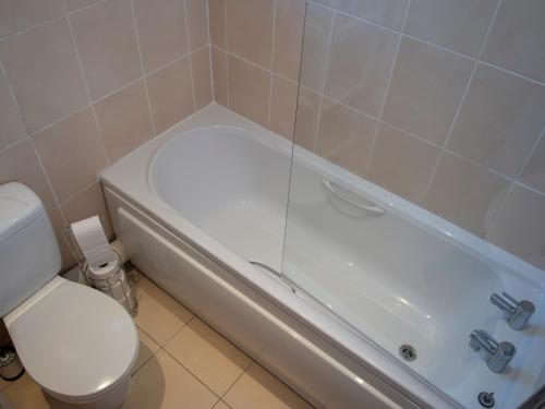een badkamer met een toilet en een bad met een toilet bij Harbour Retreat Trinity Mews in Torquay