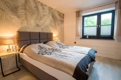 a bedroom with a large bed and a window at Apartament Muszyna in Muszyna