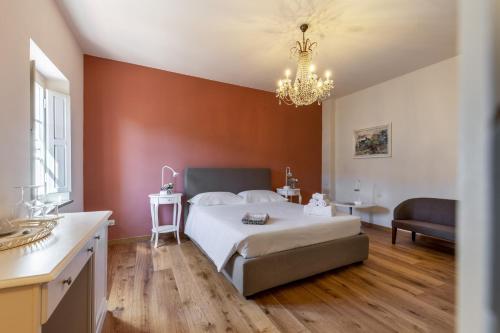 a bedroom with a large white bed and a chandelier at B&B Ninfeo dell' Arancera in Calci