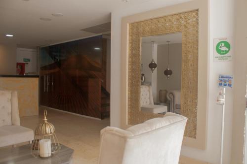 sala de estar con sofá blanco y espejo en Hotel Marrakech Cali, en Cali