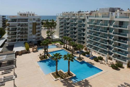 an overhead view of a pool with palm trees and buildings at Acacias Suites Apartments Salou in Salou