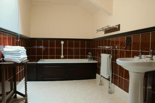 uma casa de banho com uma banheira e um lavatório em Cae'r Blaidd Country House em Ffestiniog