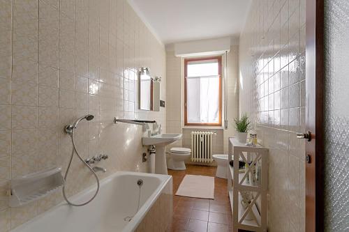 łazienka z wanną, umywalką i toaletą w obiekcie Natural chic - Close to city center and beach - parking w mieście Desenzano del Garda