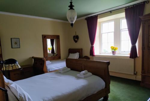 um quarto com 2 camas e uma janela em Cae'r Blaidd Country House em Ffestiniog