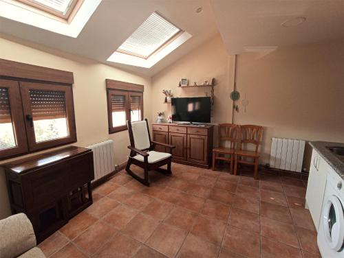 a living room with a television and a table and chairs at El Rincón del Sanabrés, Peñalara in Rascafría