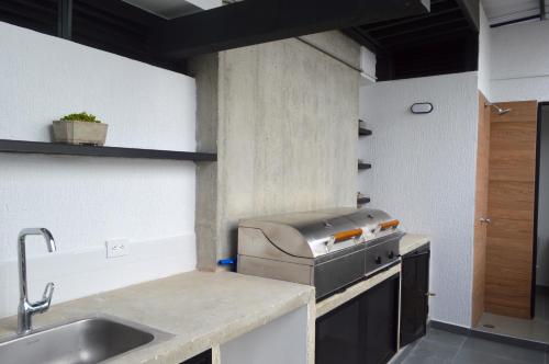 a small kitchen with a sink and a stove at Apartamento con vista y ubicación privilegiada in Armenia