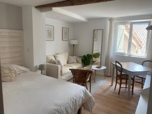 1 dormitorio con cama, mesa y sofá en Maison St Victor, en Castellane