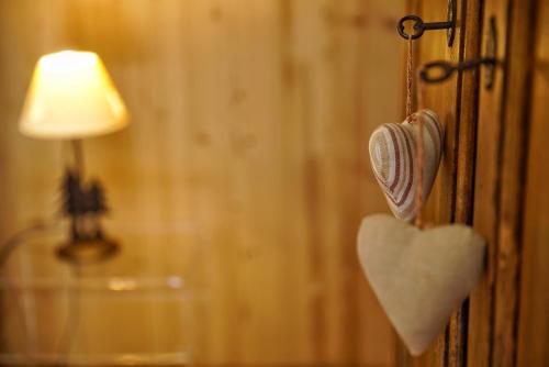 a heart hanging on a wall next to a lamp at Auberge Lou Créton di Lui Hostel in Pontboset