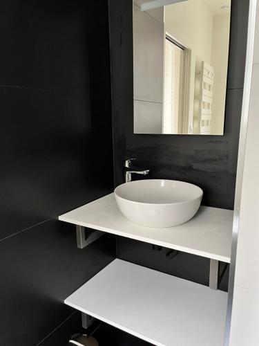 La salle de bains est pourvue d'un lavabo blanc et d'un miroir. dans l'établissement La Villa d'Auteuil, à Paris