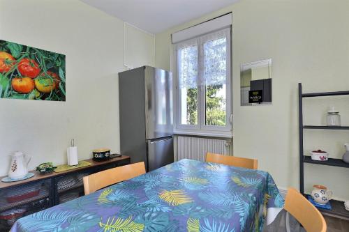 a kitchen with a table and a refrigerator at "Urbaine Colors" Appartement coloré et lumineux "Les Péri-Urbaines" in Riedisheim