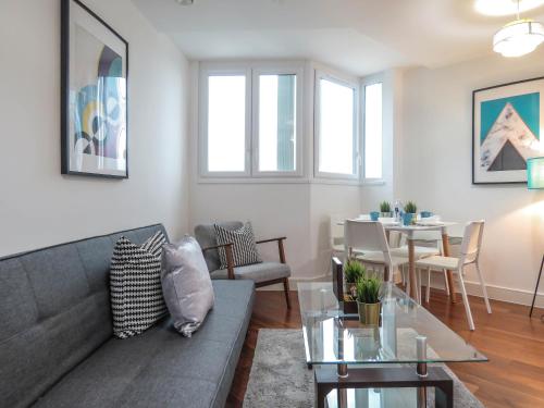 ein Wohnzimmer mit einem Sofa und einem Tisch in der Unterkunft Tudors eSuites Five Ways Two Bedroom Apartment in Birmingham