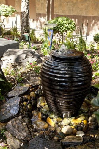 a large vase sitting on a pile of rocks at The Creekside Inn in Palo Alto