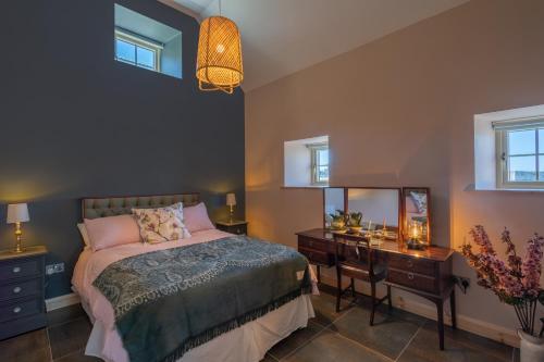 1 dormitorio con cama, escritorio y espejo en Coach House Cottage on the shores of Lough Corrib en Galway