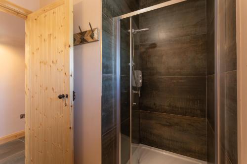 a shower with a glass door in a bathroom at Coach House Cottage on the shores of Lough Corrib in Galway