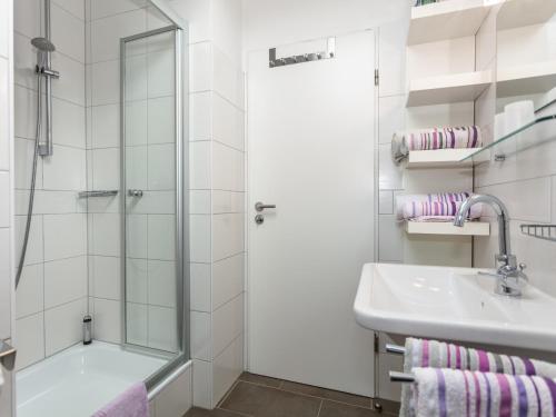 a white bathroom with a shower and a sink at Haus Schlossblick in Bad Reichenhall