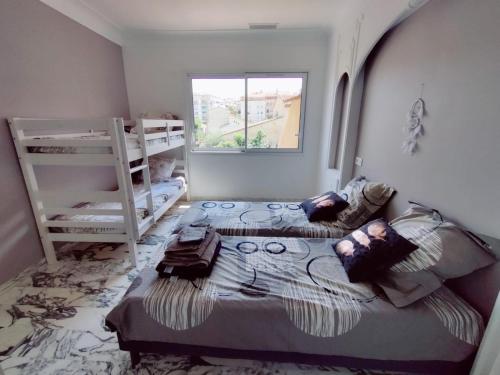 sypialnia z dwoma łóżkami piętrowymi i oknem w obiekcie La Villa Castel - Haut de villa - parkings- 3 chambres - 8 couchages - jardin - barbecue w Cagnes-sur-Mer