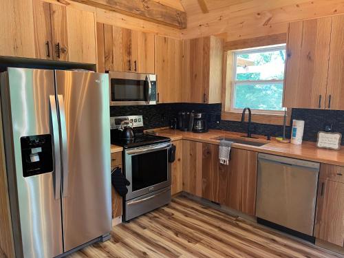 een keuken met een roestvrijstalen koelkast en houten kasten bij windrock ridge - Ethan in Oak Ridge
