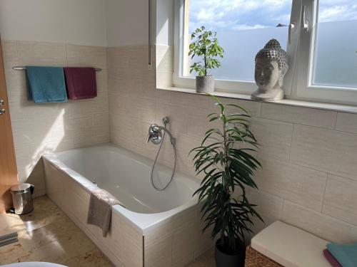 een bad in een badkamer met een plant bij Weidehaus Pförring in Pförring
