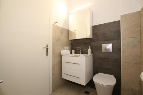 een badkamer met een wit toilet en een wastafel bij Sunset Sea View Villa 9 in Afionas