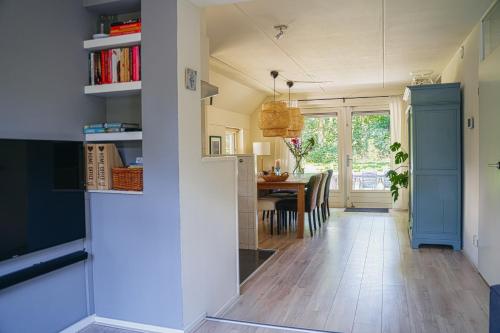 eine Küche und ein Esszimmer mit einem Esstisch in der Unterkunft Cottage Hazenhorst - paradijs aan het bos in IJhorst