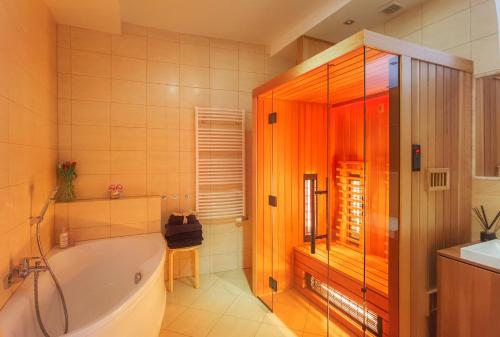 a bathroom with a tub and a shower and a sink at Apartament Rynek - Zielona Kamienica in Duszniki Zdrój