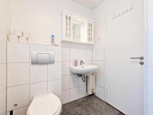 a white bathroom with a toilet and a sink at Tolstov Apartments - 3 Room Apartments with Garden - 20 Min Messe DUS & Airport DUS in Meerbusch