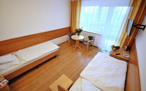 a room with two beds and a table and a window at SP ZOZ Sanatorium Uzdrowiskowe MSWiA w Kołobrzegu in Kołobrzeg
