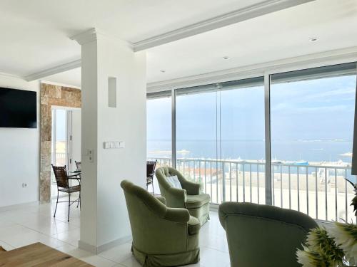 un soggiorno con sedie e vista sull'oceano di Luxury family apartment in Roses a Roses