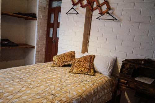 a bedroom with a bed with leopard pillows on it at Chuza Longa Home in Guamote