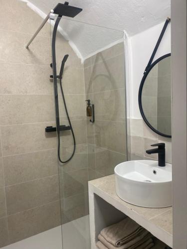 y baño con ducha, lavabo y espejo. en Maison St Victor, en Castellane