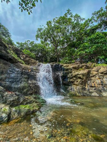 a waterfall on the side of a rocky cliff at Cabañas Lamaite in Sámara