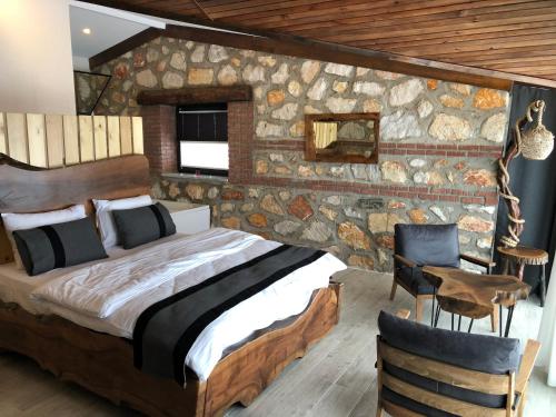 ein Schlafzimmer mit einem Bett und einer Steinmauer in der Unterkunft Masklavi in Kestel