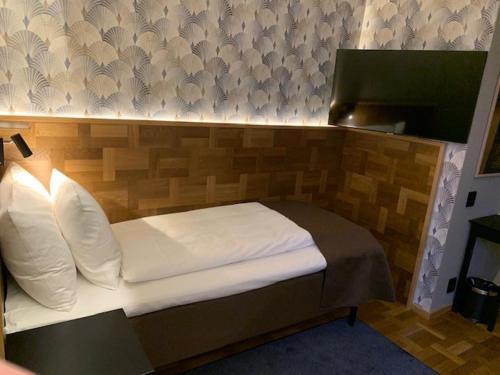 a bedroom with a bed with a wooden headboard at Nybro Stora Hotellet in Nybro