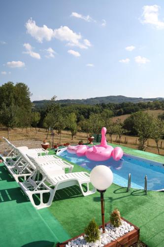 a swimming pool with a pink inflatablelatable raft at Apartman Nana in Gornji Milanovac