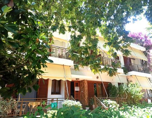 een gebouw met balkons en bomen ervoor bij Papadioti Apartments in Pefki