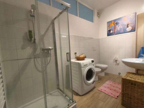 a bathroom with a shower and a washing machine at Via dei Ginepri in Noli