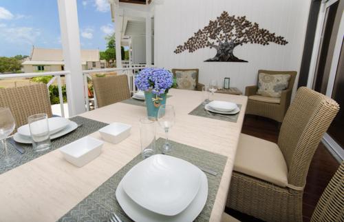 uma sala de jantar com uma mesa com cadeiras e um estofados de esteira em Lantana Resort Barbados by Island Villas em Saint James