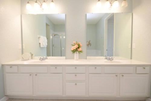 ein Badezimmer mit zwei Waschbecken und einem großen Spiegel in der Unterkunft New! Stunning Vista Cay Lake View Excellence Near all Parks, and walk to the Convention Center in Orlando