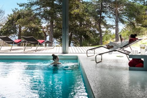 a woman swimming in a swimming pool at Casa das Penhas Douradas - Burel Expedition Hotel in Manteigas