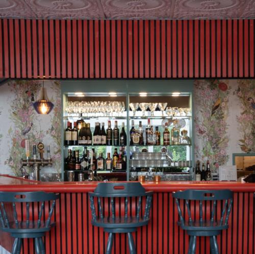 a bar with two blue chairs and bottles of alcohol at Motel Chelsea in Chelsea