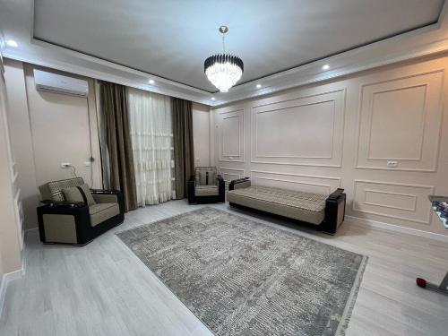 sala de estar con cama, sofá y alfombra en Караван Сарай 3, en Türkistan